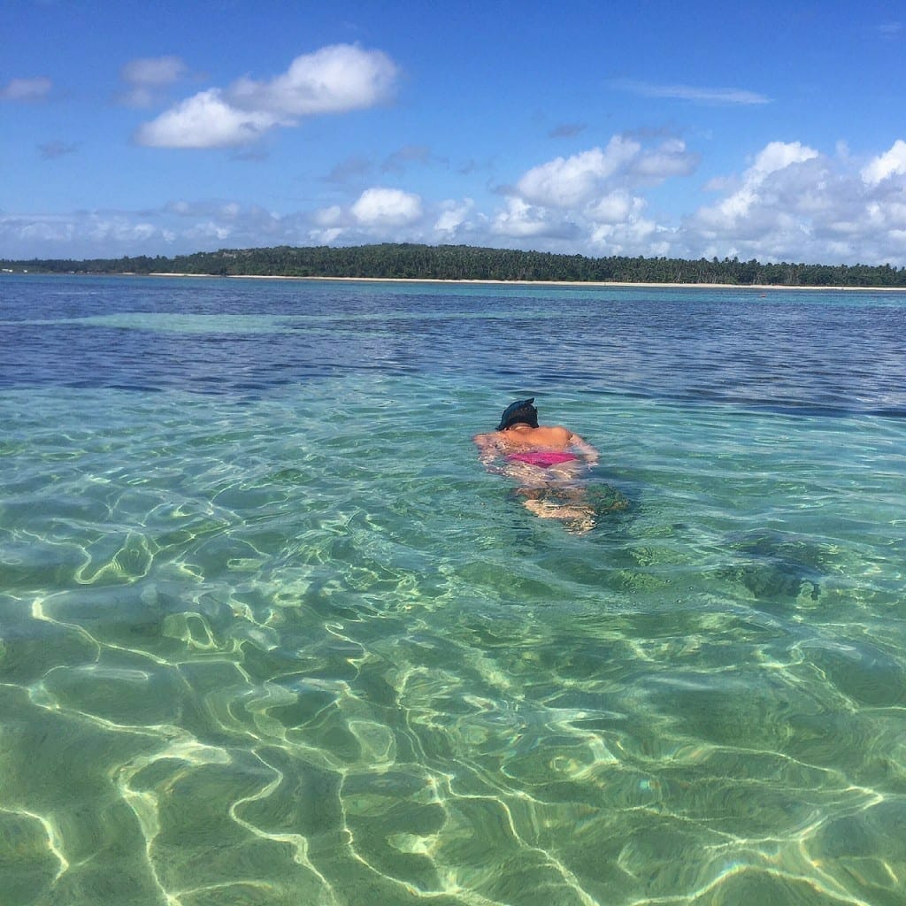 Um homem nadando nas piscinas naturais da Praia de Moreré, Boipeba, Bahia