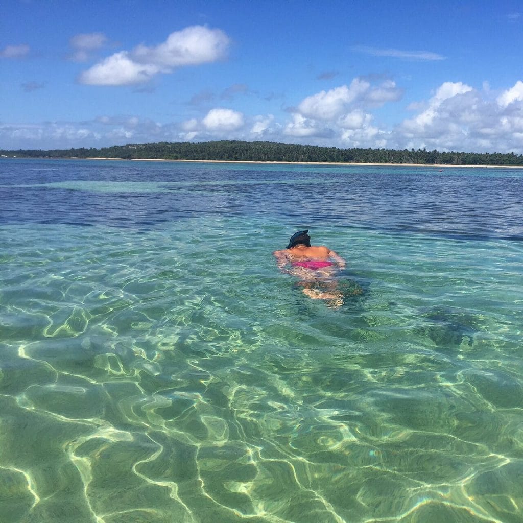 a man swimming in the natural pools of Moreré Beach on Boipeba Island, Bahia, Brazil