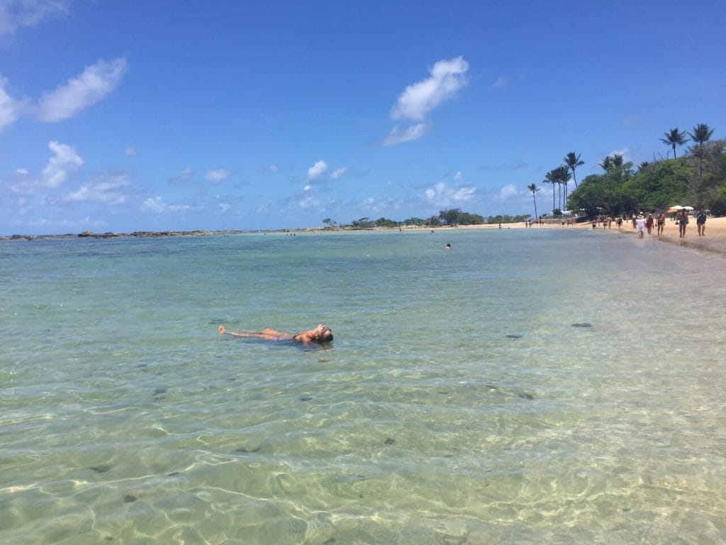 A woman floating in the crystalline water of the Third beach, Morro de Sao Paulo, Brazil