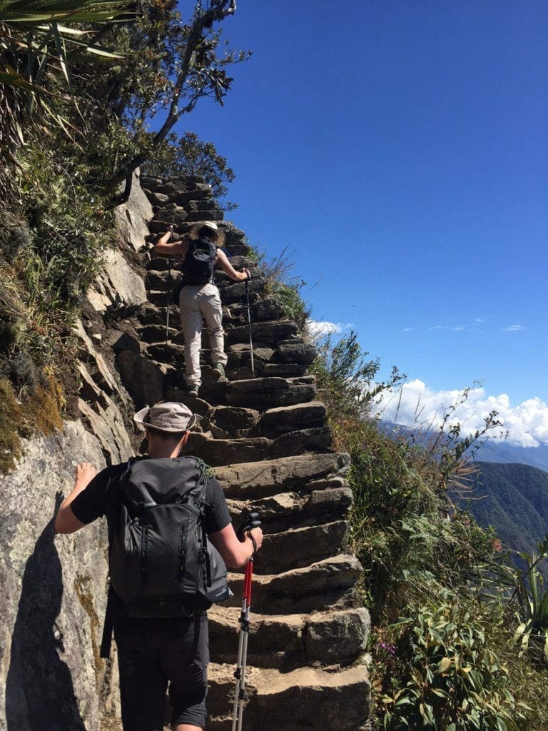 a couple walking up some steps at Machu Picchu Mountain, Peru