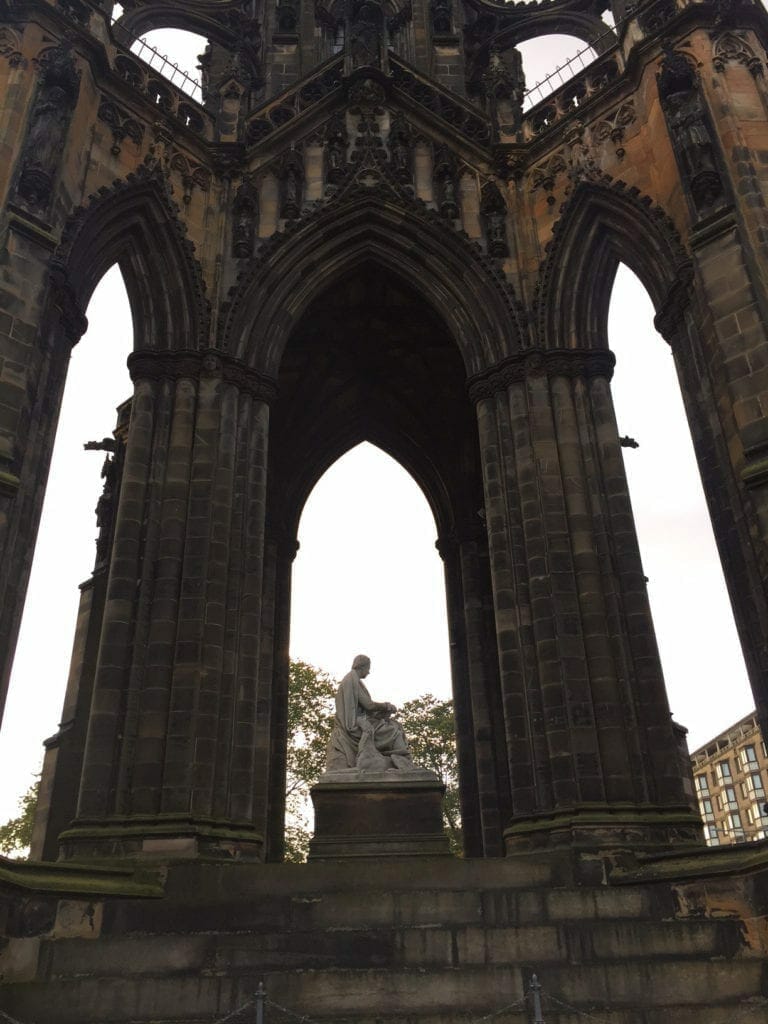 os arcos em estilo gótico vitoriano com uma estátua no meio do Monumento Scott em Edimburgo