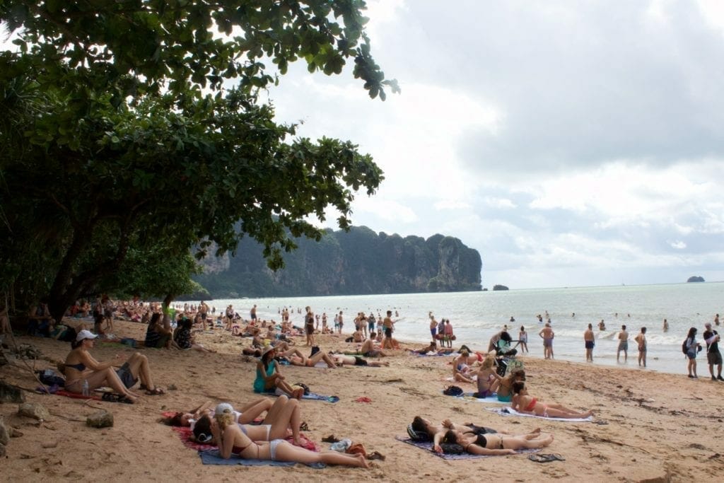 People at Ao Nang Beach, which is enveloped by limestone mountains covered with vegetation