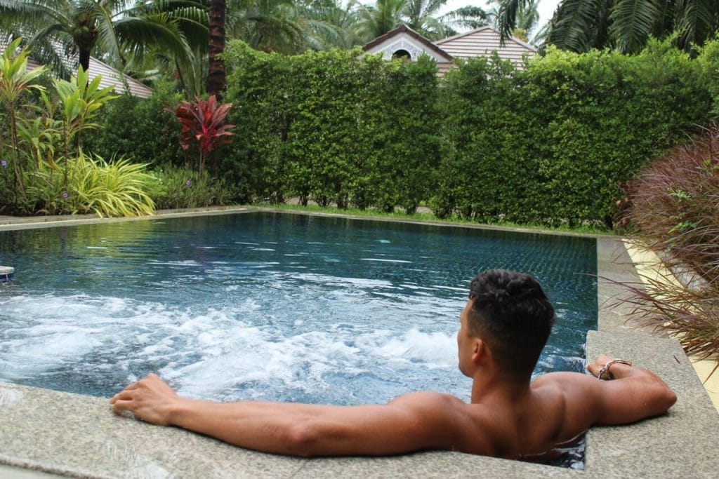 A man in a swimming pool that is surrounded by plants