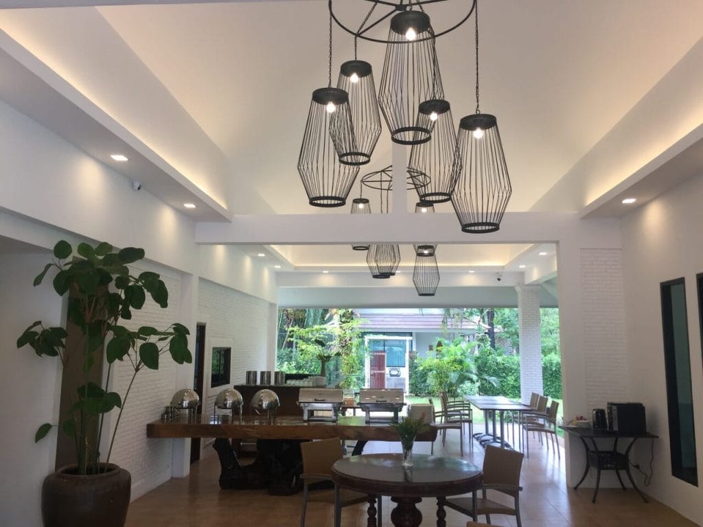 the dinner area of Alisea Pool Villas, with tables, chairs, plants and a chandelier