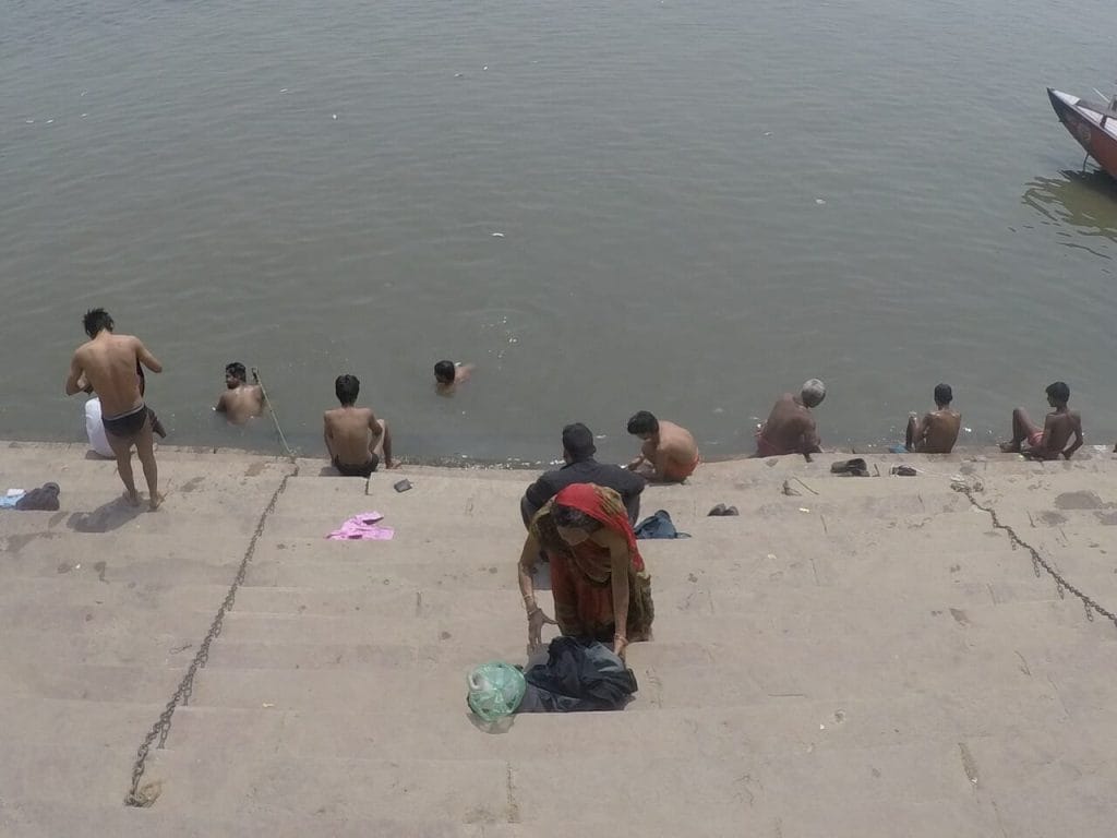 Pessoas tomando banho e lavando roupas nas águas do Rio Ganges