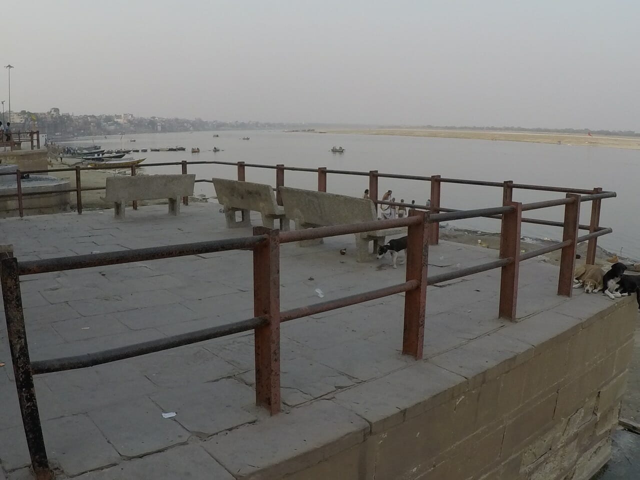 uma plataforma cimentada cercada para cremação dos corpos nas margens do Rio Ganges