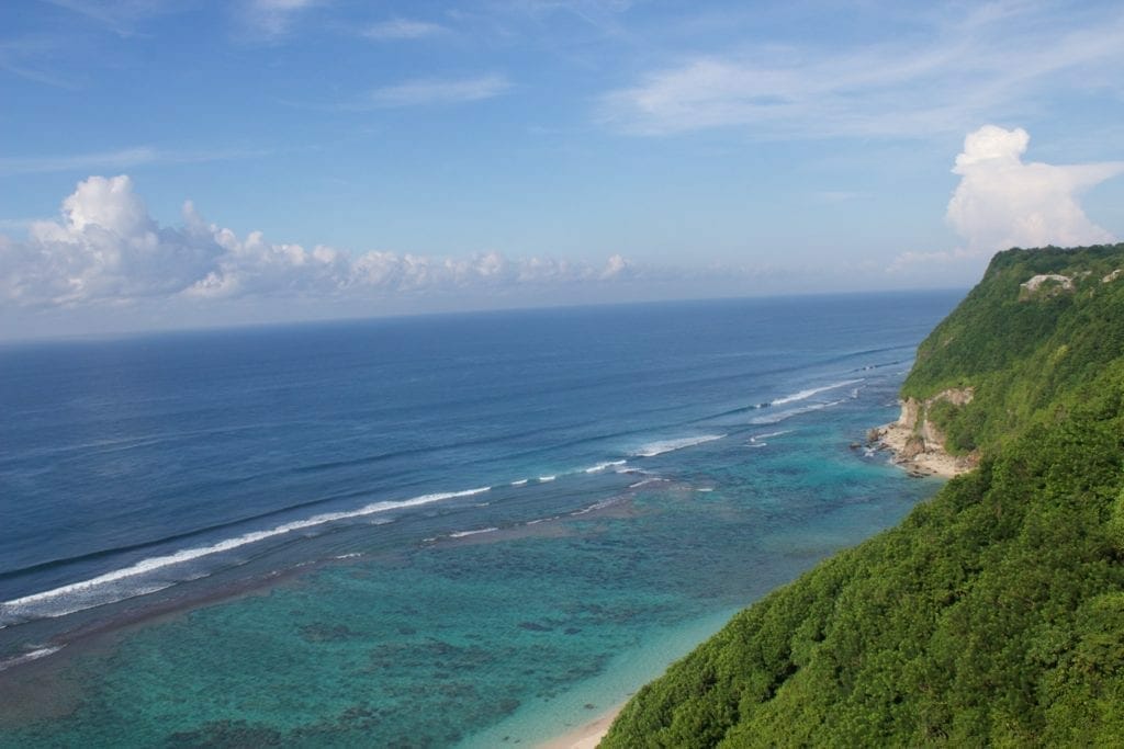 La playa Karma de Bali está rodeada de acantilados cubiertos de vegetación y tiene aguas azules cristalinas.