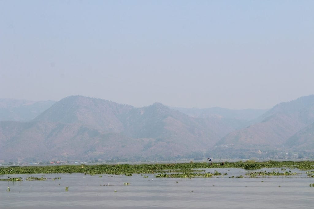 the shallow waters of Inle Lake, the second biggest lake in Myanmar, surrounded by mountains 