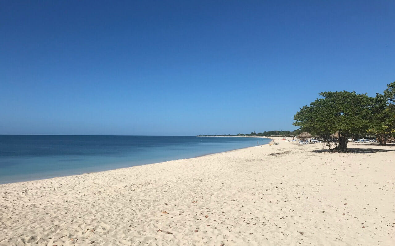 Playa Ancón, Trinidad, Cuba, and its white sand, and crystal-clear blue water dotted by lush vegetation