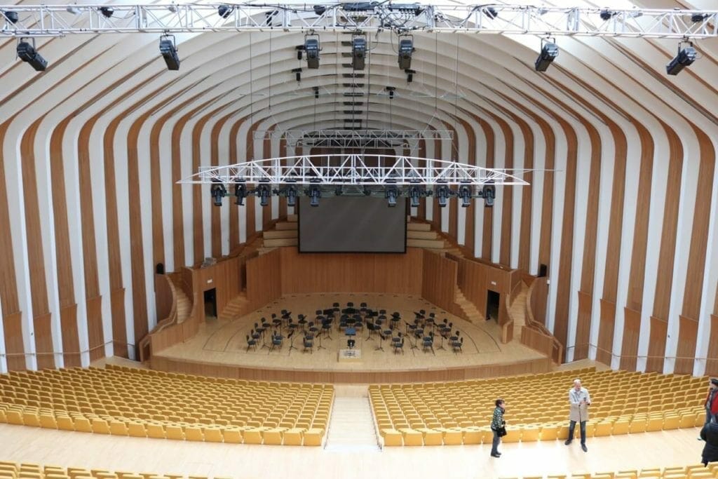 o interior da sala principal da Opera House de Valência com cadeiras de madeira na arquibancada e um palco com piso de madeira