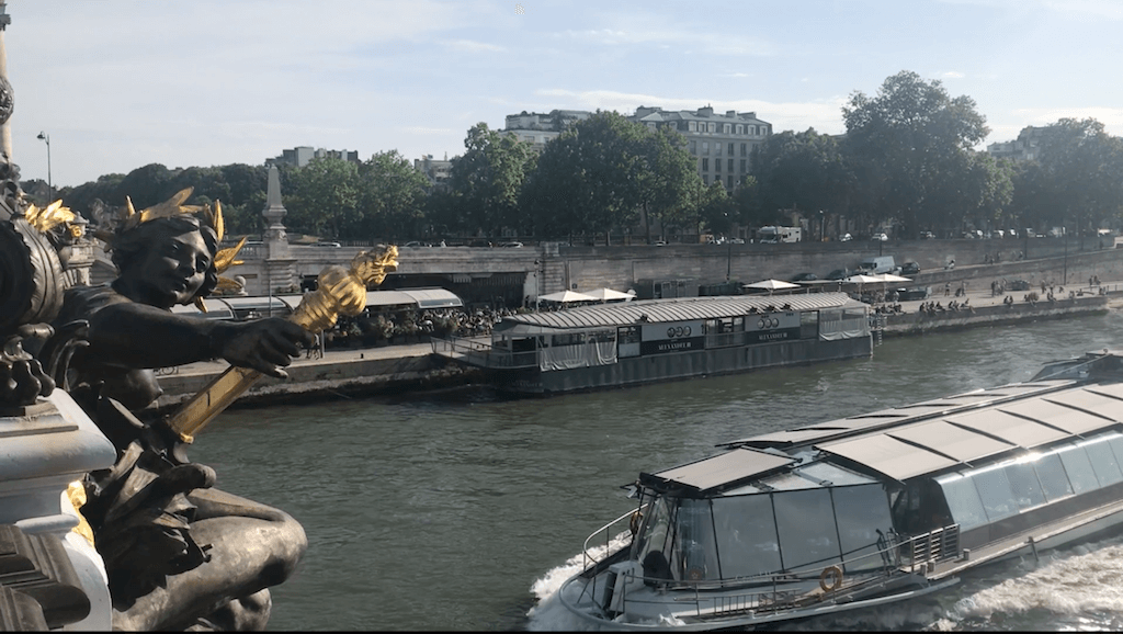 A bateaux bouche passing under the gorgeous bridge Pont Alexander III