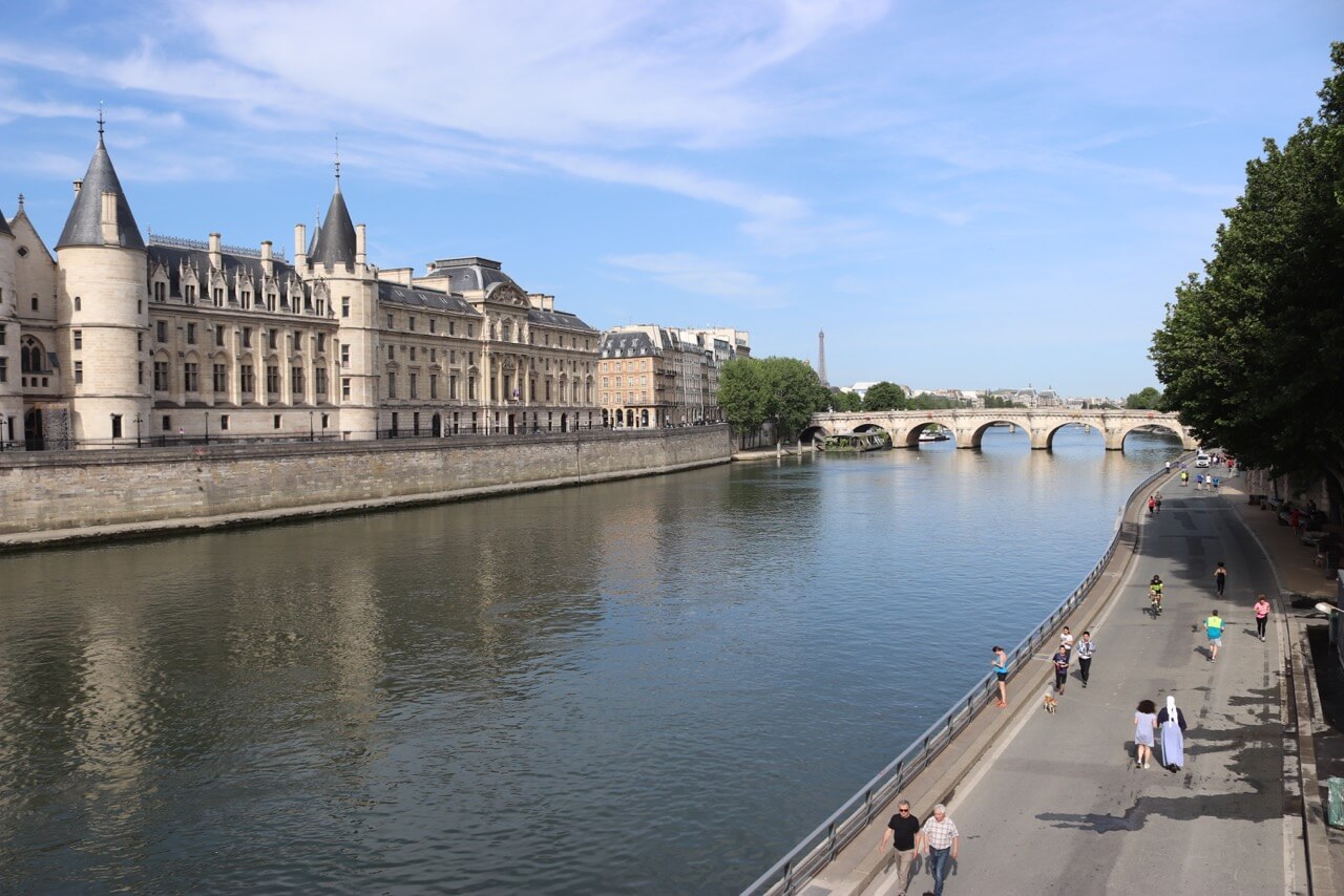 Margem do Rio Sena na região de Íle de la Cité com o La Conciergerie no lado esquerdo da foto e a Torre Eiffel ao fundo.