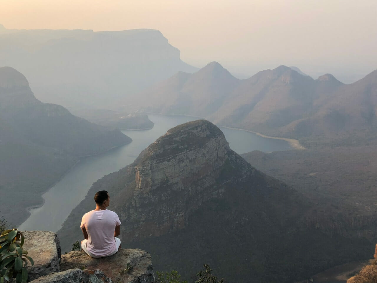 Pericles Rosa seating on a rock at Three Rondavels View Point, South Africa 