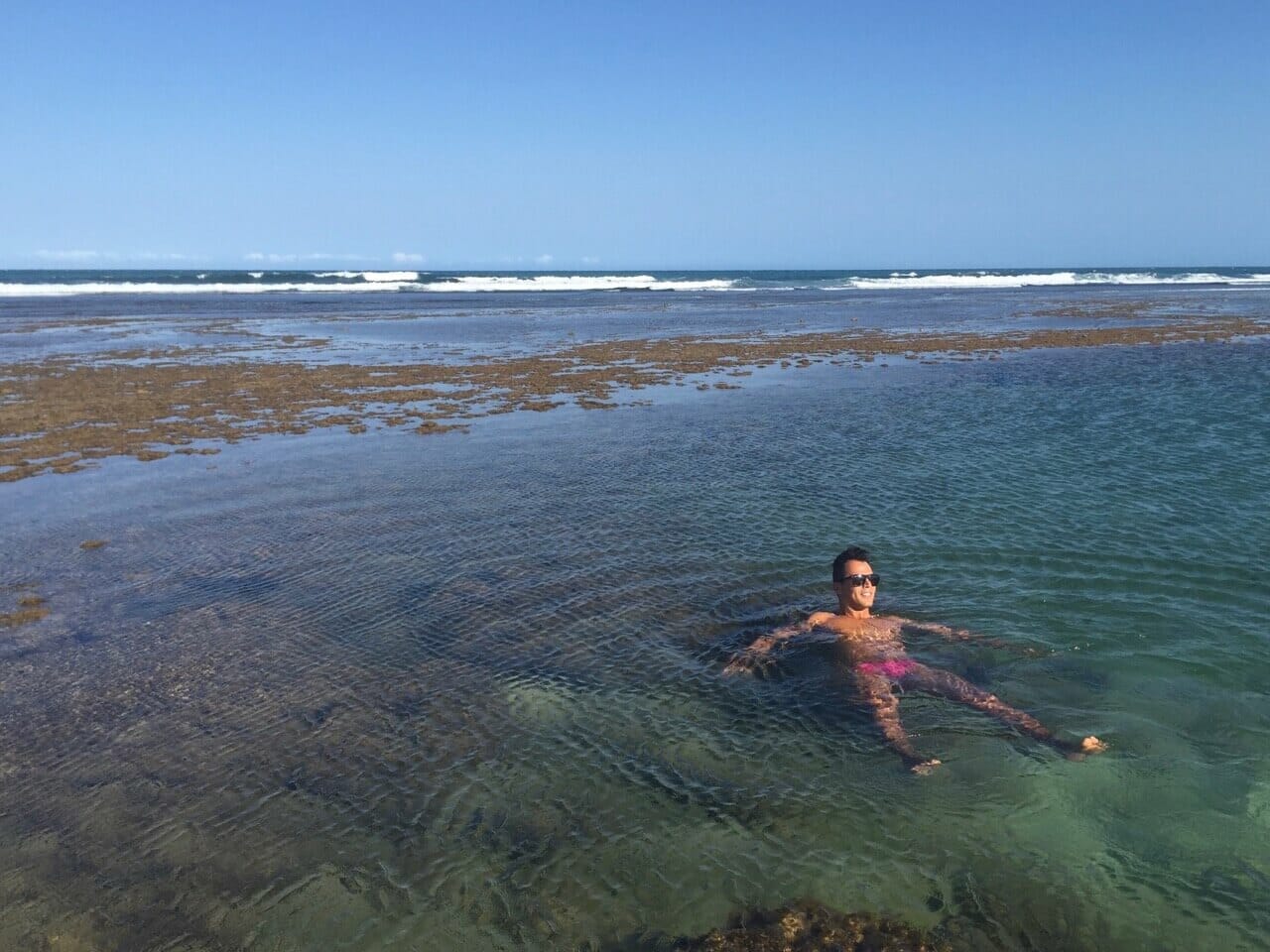 Péricles Rosa usando óculos escuro e sunga rosa curtindo as piscinas naturais da Praia do Papa Gente, Praia do Forte, Bahia