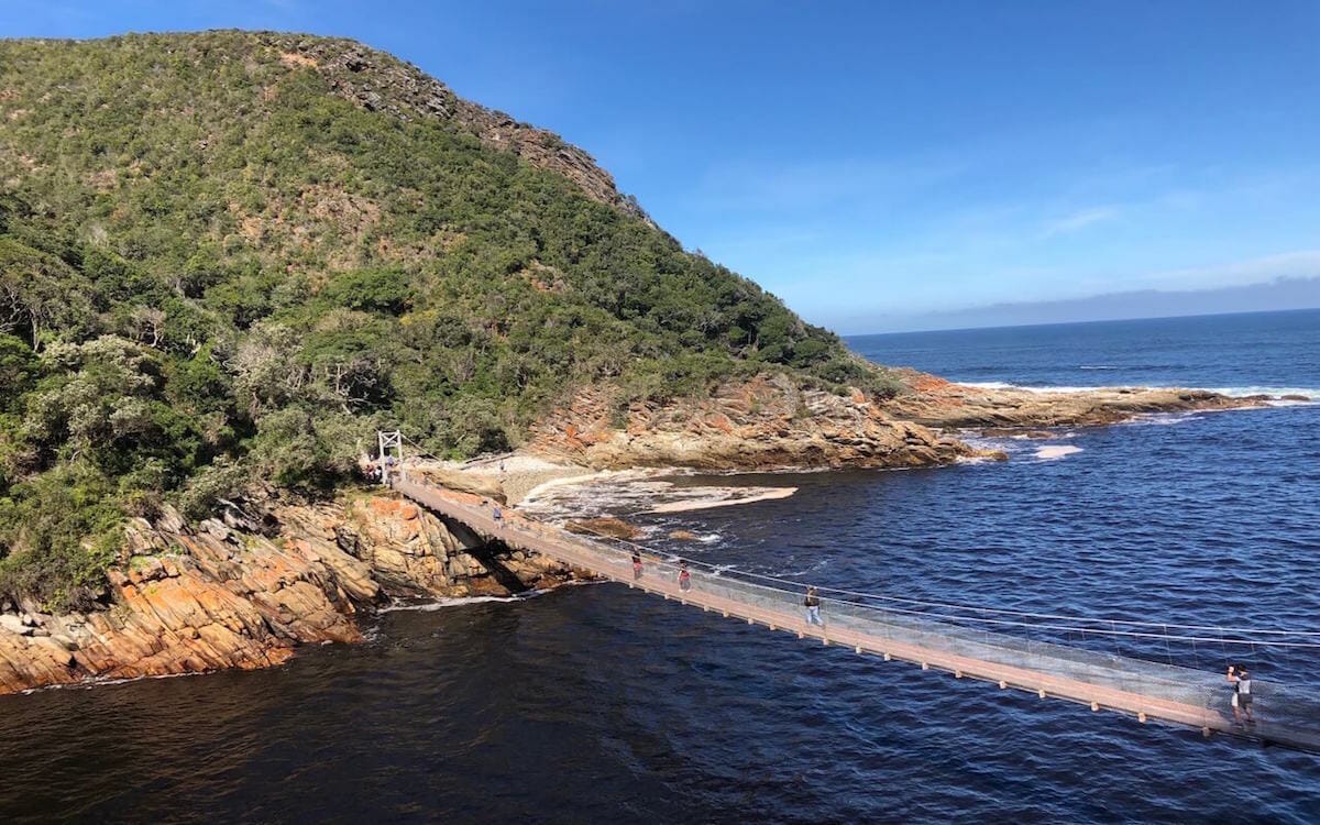 Uma ponte suspensa em Storms Rive Mouth, Parque Nacional Tsitsikama, África do Sul