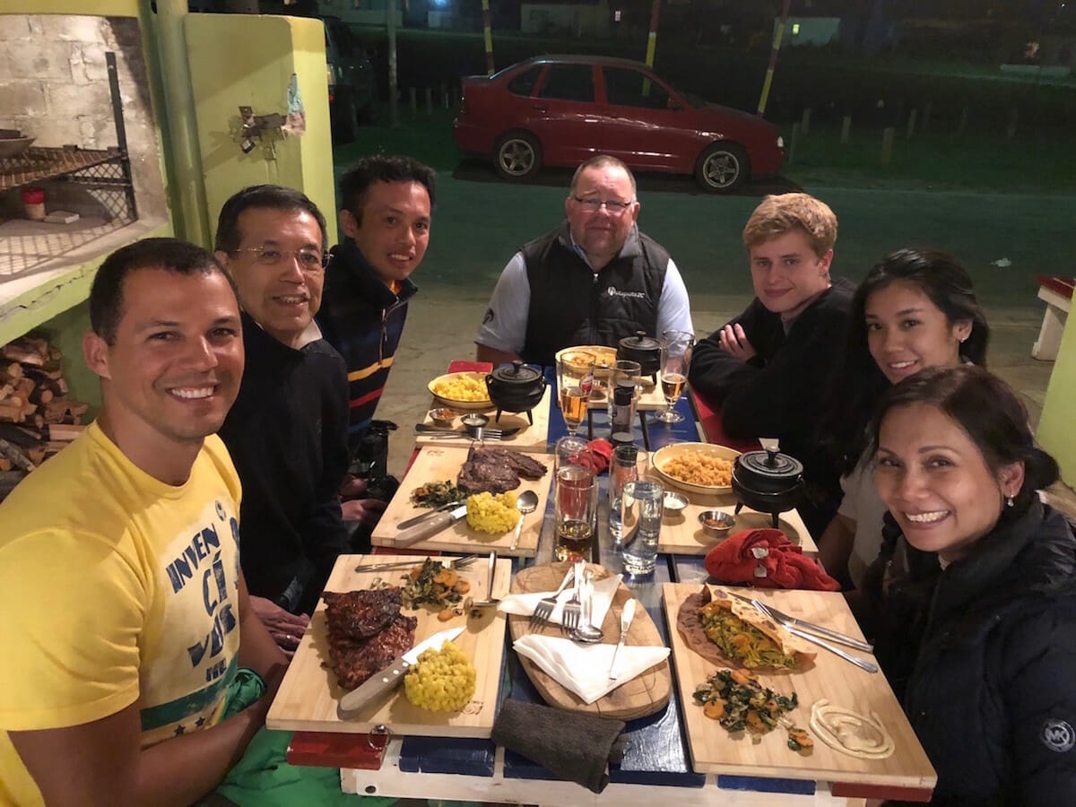 sete pessoas sentadas à mesa no restaurante Awethu, Jeffreys Bay, África do Sul