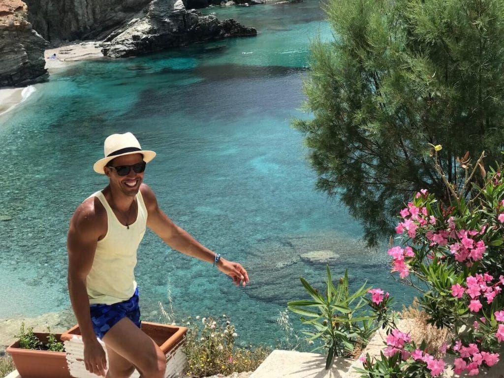 A man walking up stairs on Agali Beach with the sea in the background, Folegandros, Greece