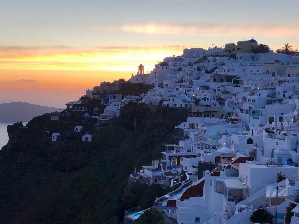 Whitewashed houses on the top of a cliff in the village of Imerovigli, Santorini, during the sinset