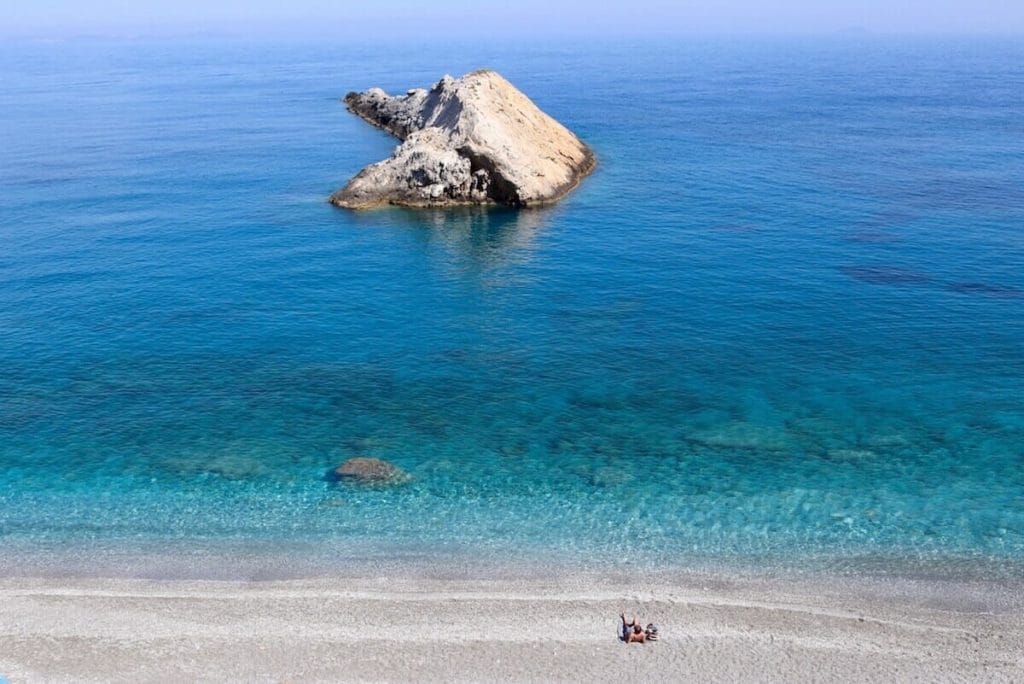 A man sunbathing at Katergo Beach, Folegandros, Greece