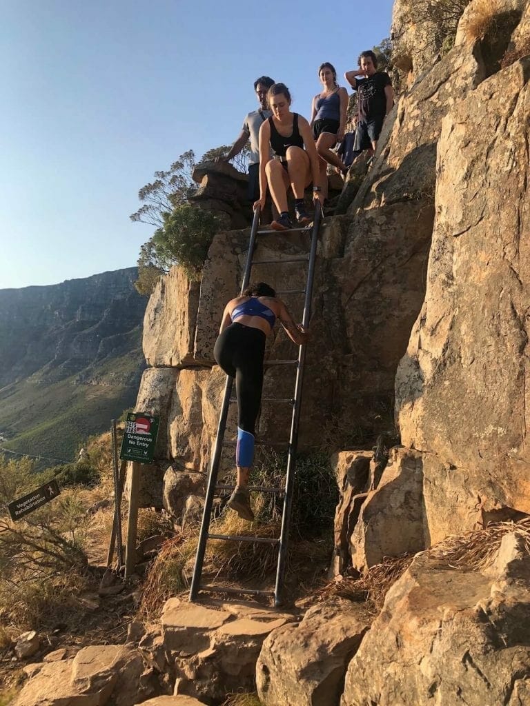 a group of young ladies climbing down one of the latters that gives access to Lion's Head summit