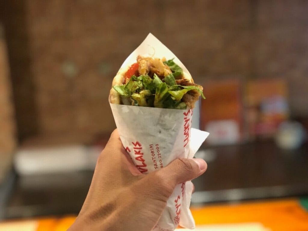 A hand holding a gyro in one of the restaurants in Santorini