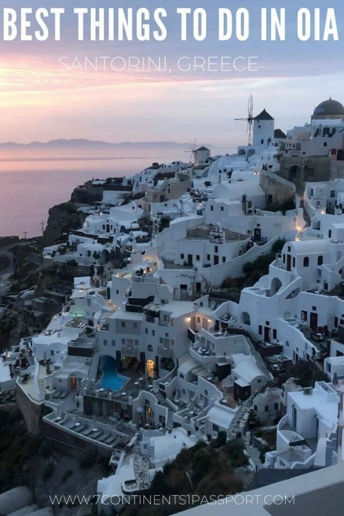 whitewashed houses on the top of a cliff in the Oia, Santorini, at sunset
