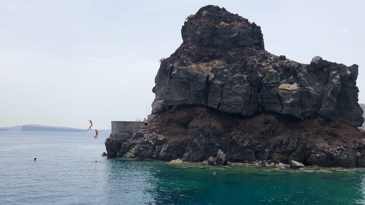 Gente a saltar al mar desde los acantilados de Ammoundi Bay, Santorini