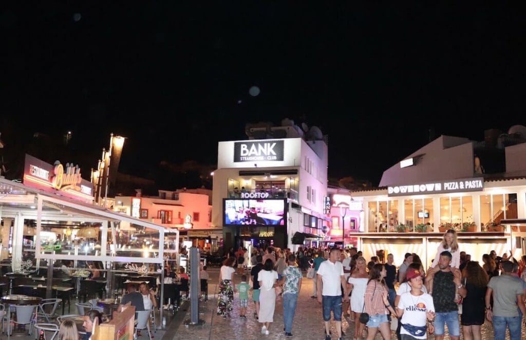 People walking on Albufeira Old Town in the evening with some restaurants with outside tables and bars 