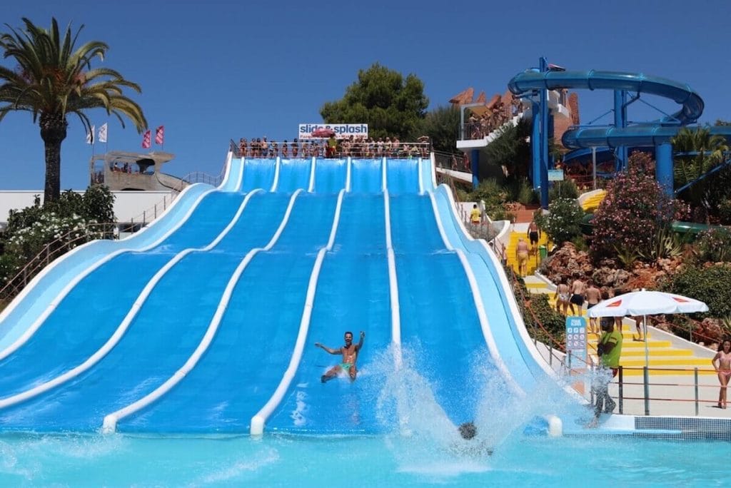 Un hombre bajando en un tobogán de agua en parque acuático Slide & Splash en Algarve, Portugal