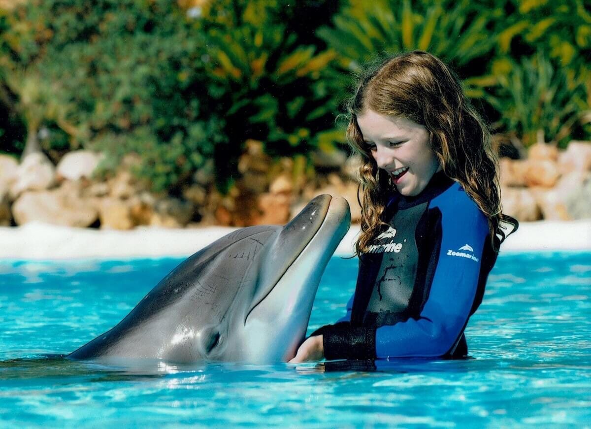 Una niña interactuando con un delfín en Zoomarine Albufeira, Portugal