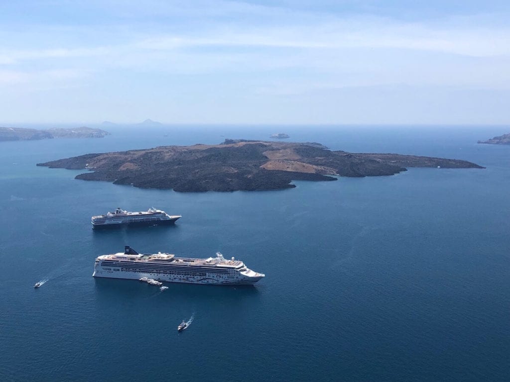 Two cruise ships sailing in the Aegean Sea near the island of Nea Kameni, Santorini, Greece