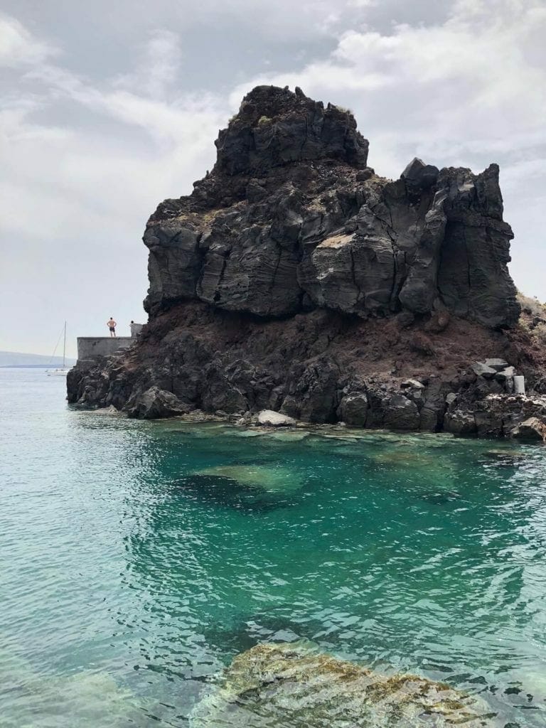 People cliff jumping on Ammoudi Bay, Santorini