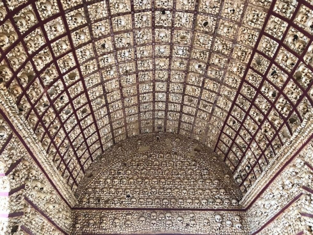 the interior of Faro Bone Chapel has walls and ceiling covered with bones and skulls