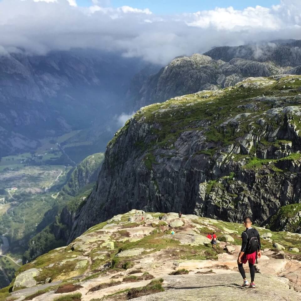 A man walking on the top of Kjerag Mountain hiking to Kjeragbolten