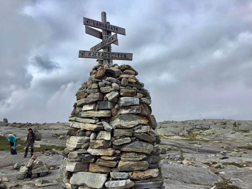 Kjeragbolten sign on the top of small tower made with rocks on Kjerag Mountain