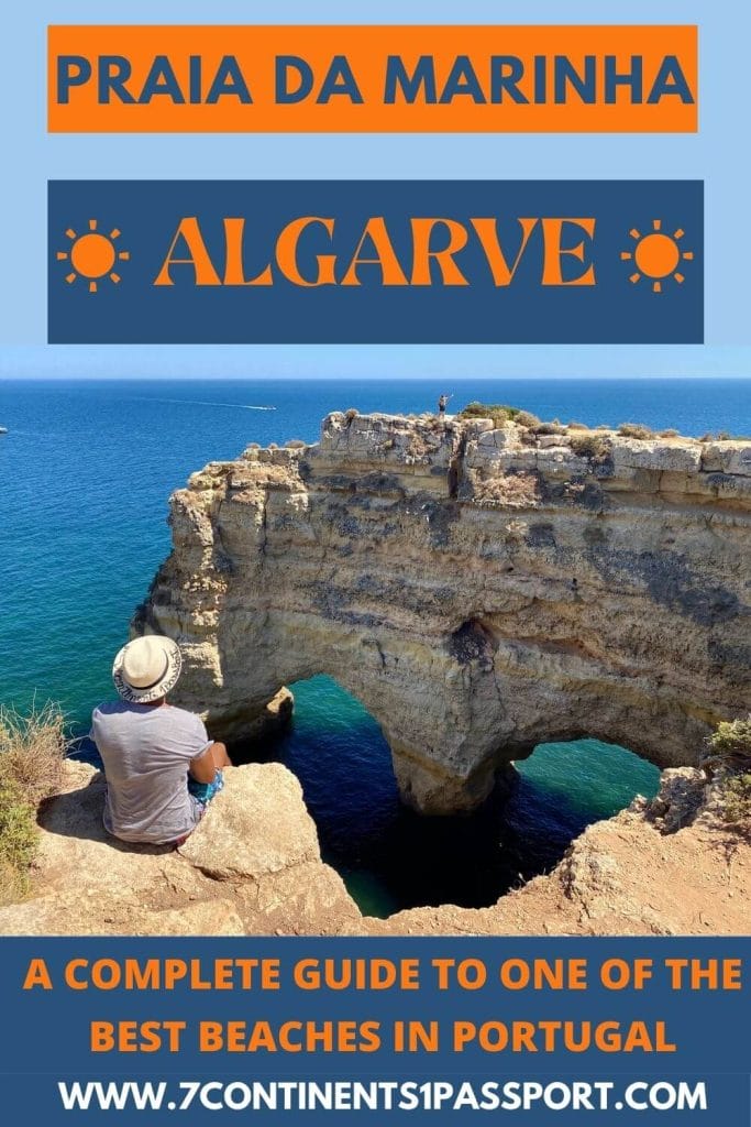 A man sitting on the edge of Marinha Beach near a heart-shaped rock