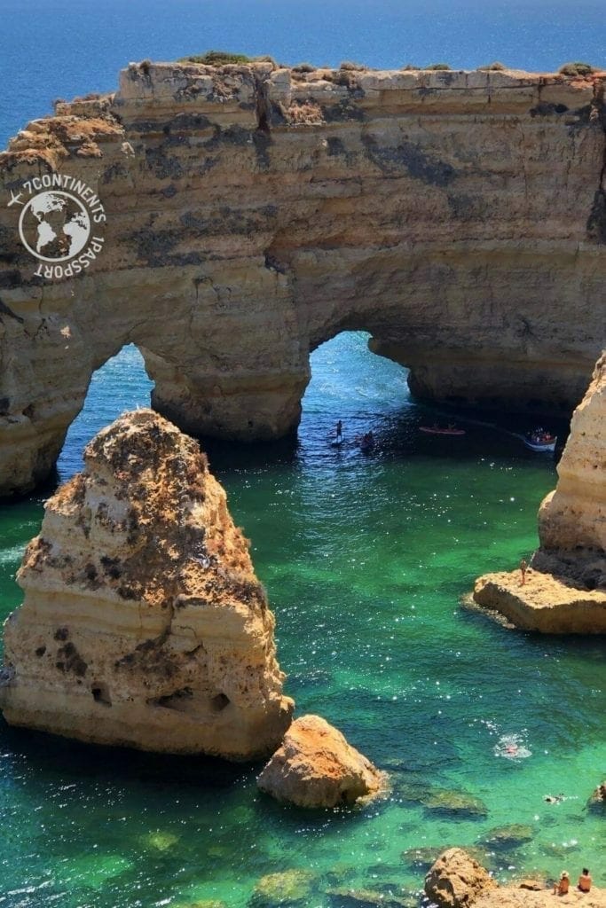 Marinha Beach, Algarve, Portugal, with its crystal-clear water, massive yellow limestone cliffs and sea arches.