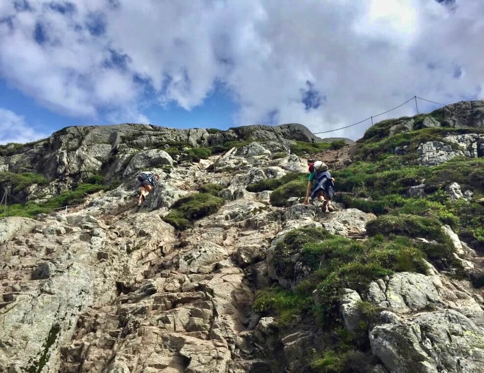 Two people scrambling up on Kjerag Mountain to get to Kjeragbolten