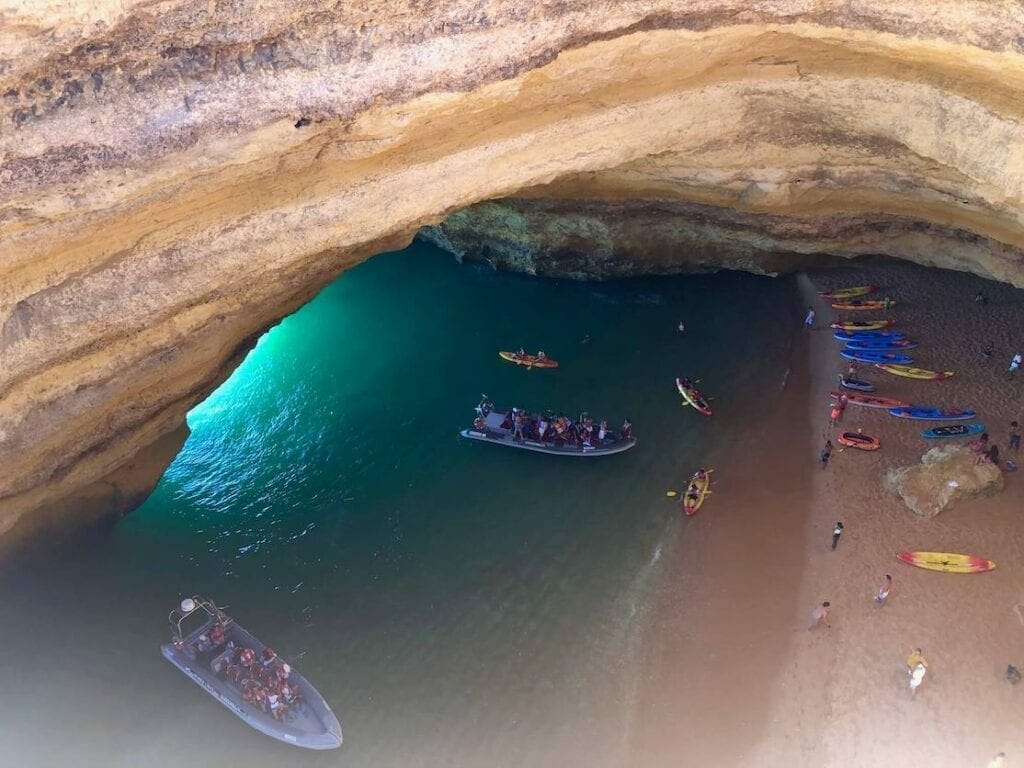 A boat and some kayaks inside Benagil Cave, Algarve, Portugal