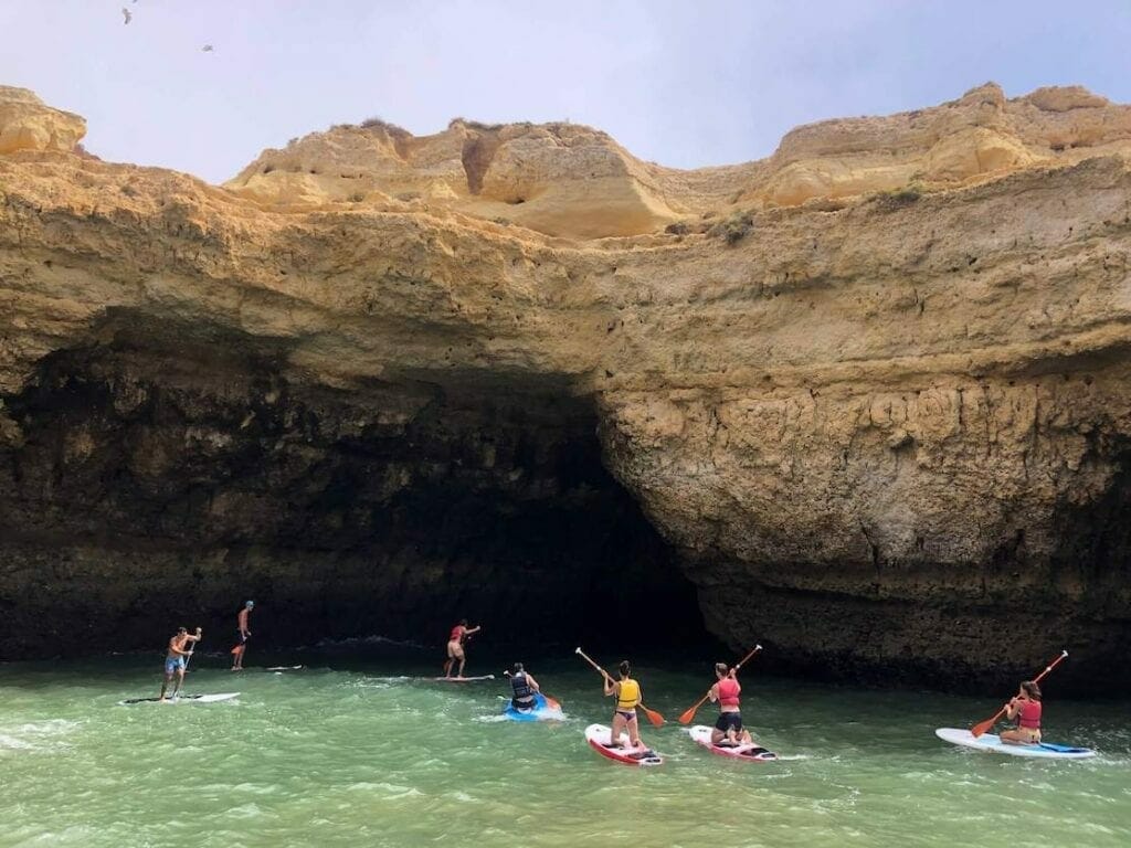 People entering into a cave during a SUP tour in the Algarve, Portugal