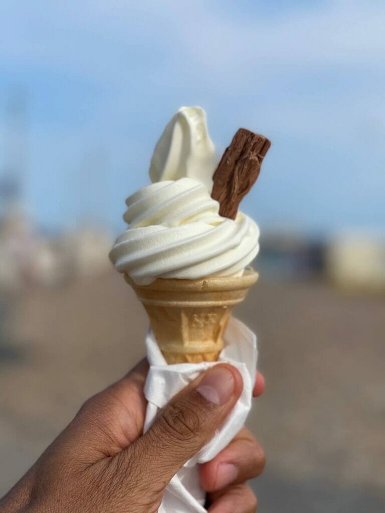 A hand holding a 99 flake vanilla ice cream at Brighton Beach