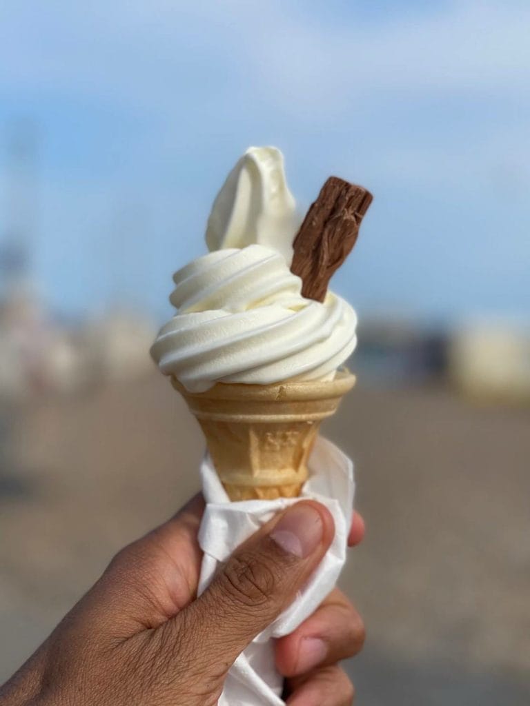 A hand holding a 99 flake vanilla ice cream at Brighton Beach