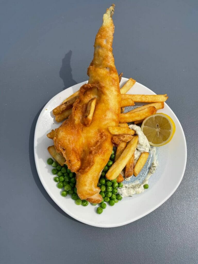 A white dish with fish and chips served at Brighton Beach Club