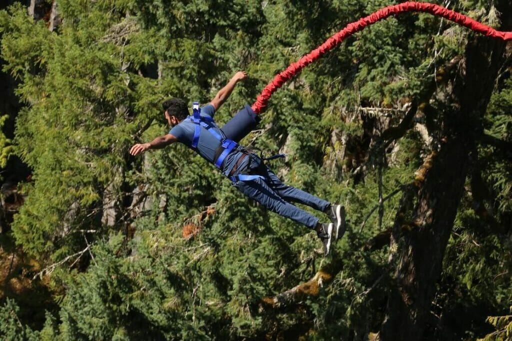 A man wearing blue clothes bungee jumping
