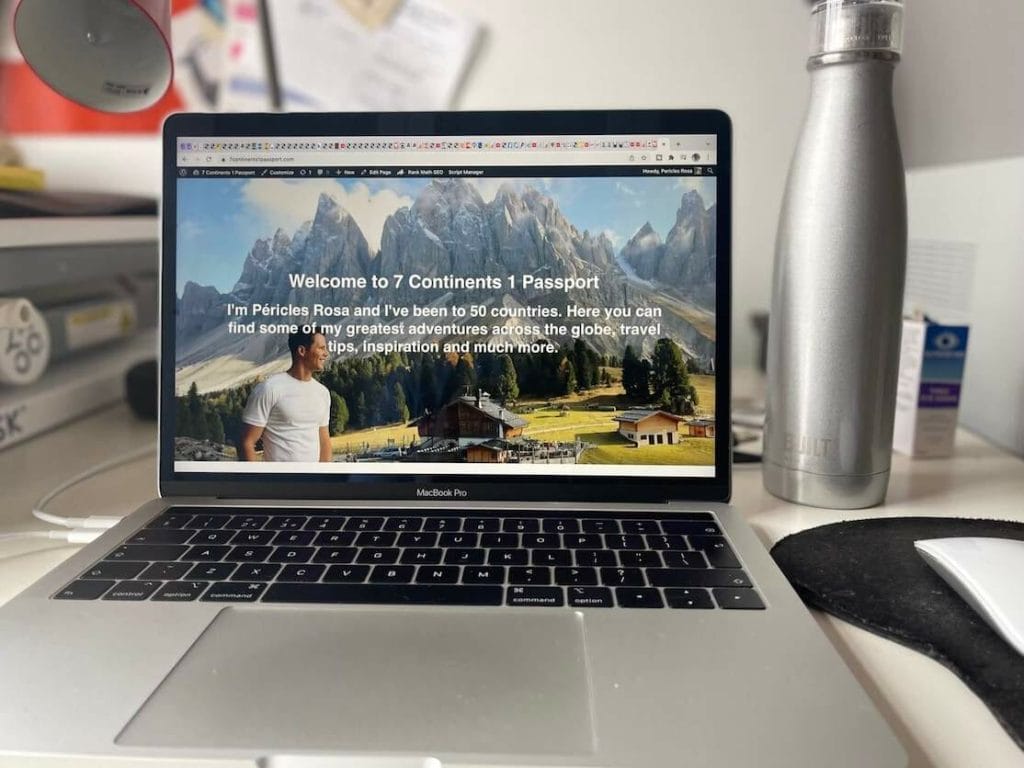 A laptop and a grey reusable bottle of water on a home office desk