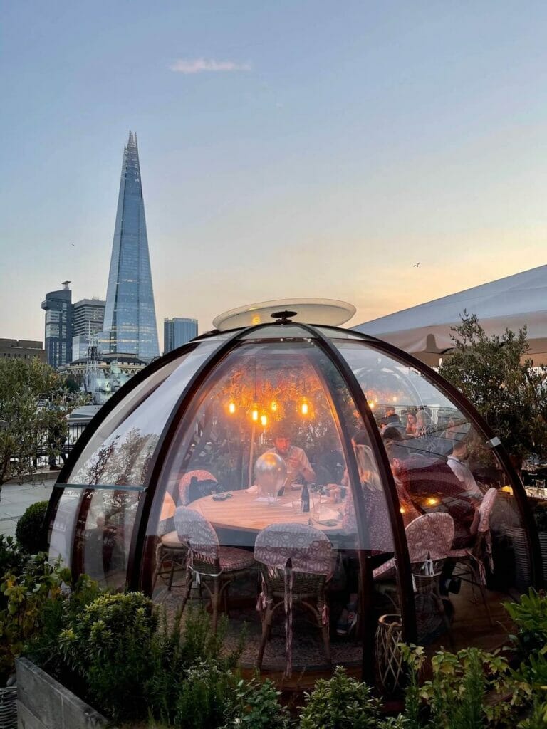 One of the igloos of Coppa Club Tower Bridge, London, and The Shard in the background
