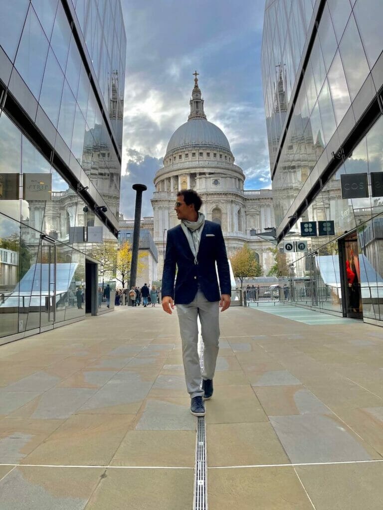Um homem andando no One New Change com a Saint's Paul Cathedral de fundo, Londres