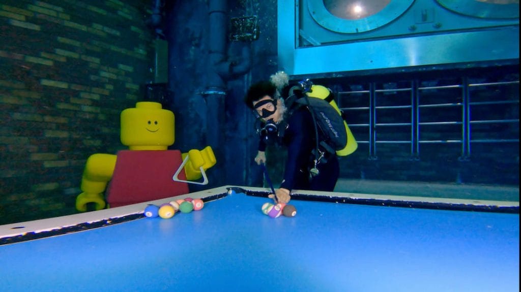 a man playing snooker in a sunken city at Deep Dive Dubai