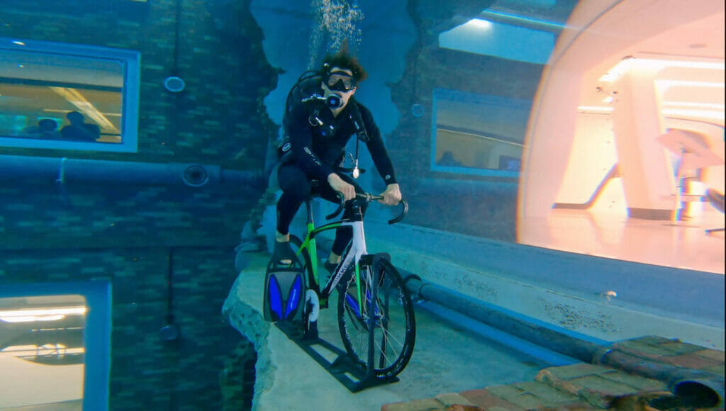 Um homem andando de bicicleta na cidade submersa de Deep Dive Dubai