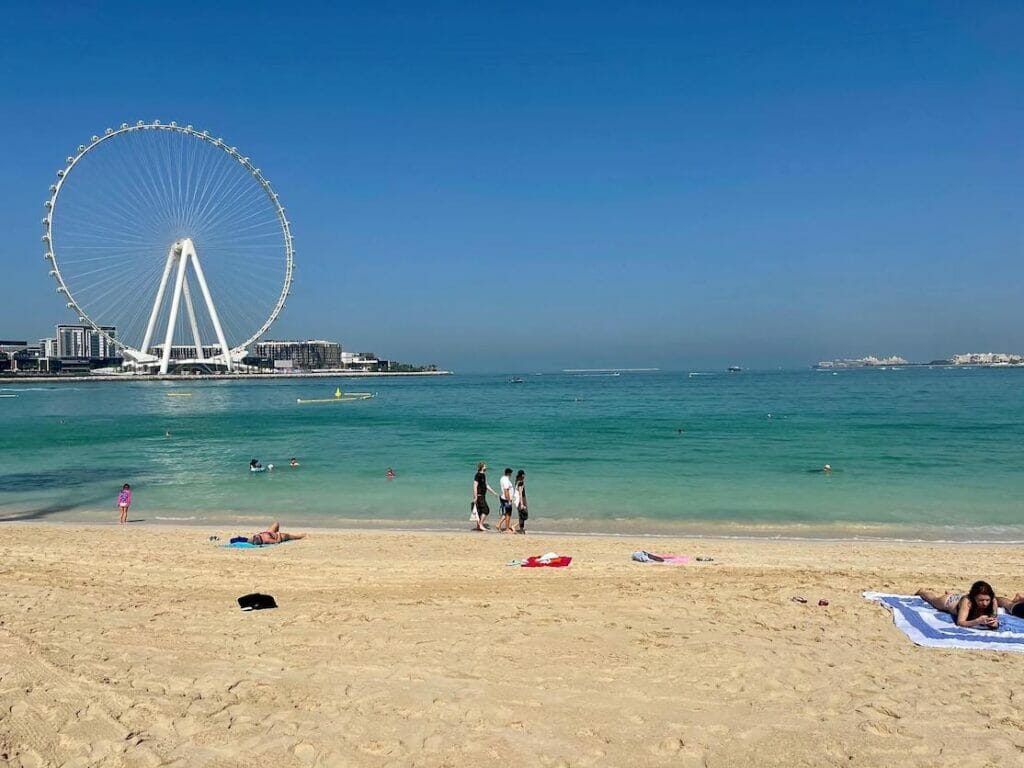 Gente caminando y tomando el sol en JBR Beach, Dubai
